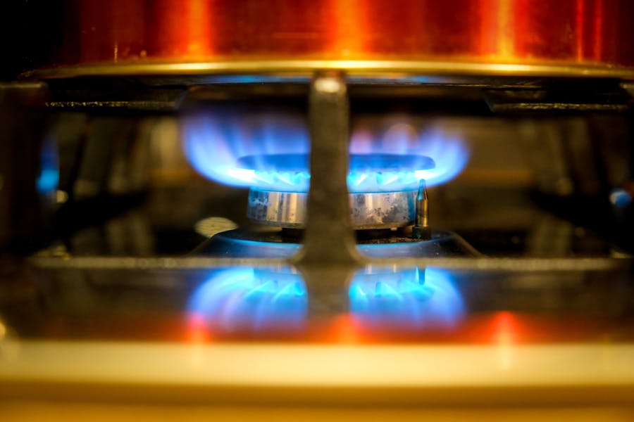 Close-up of a blue natural-gas flame on a stove burner