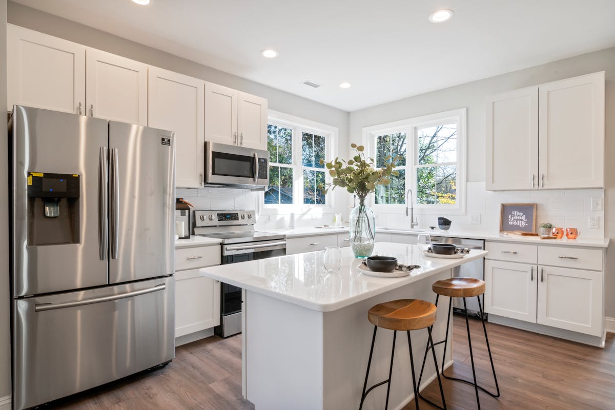 Modern Toronto kitchen with stainless steel French-door fridge, range, and over-the-range microwave