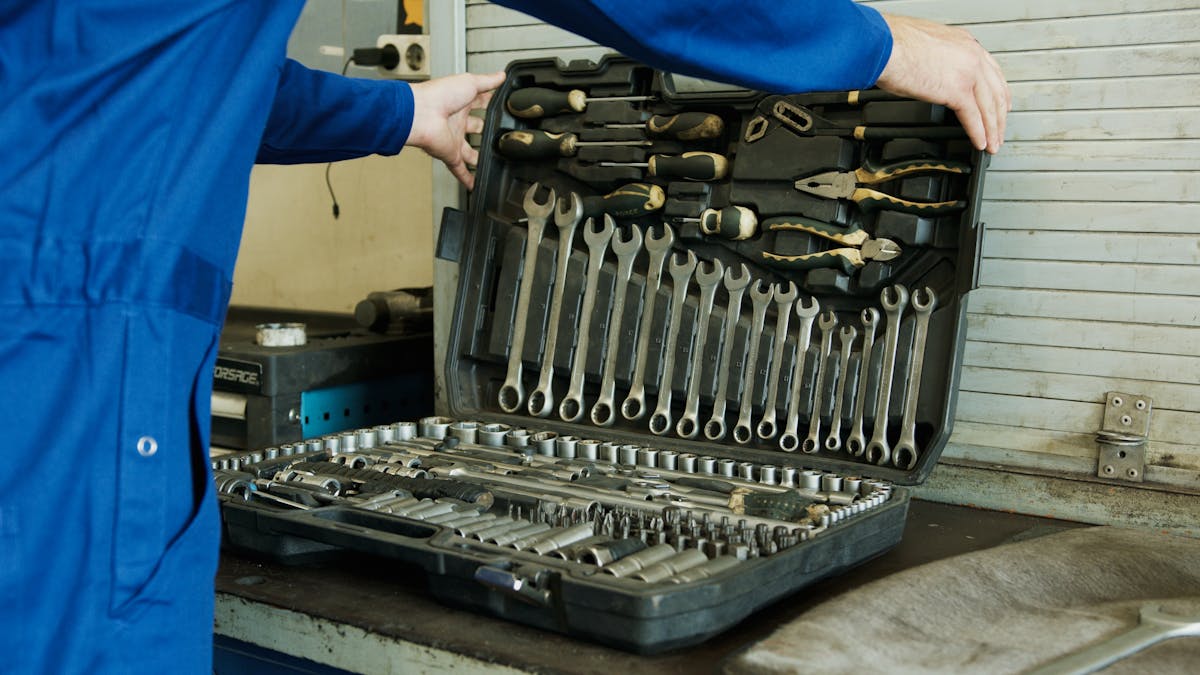 Technician opening a fully-stocked tool case with wrenches, sockets, and screwdrivers